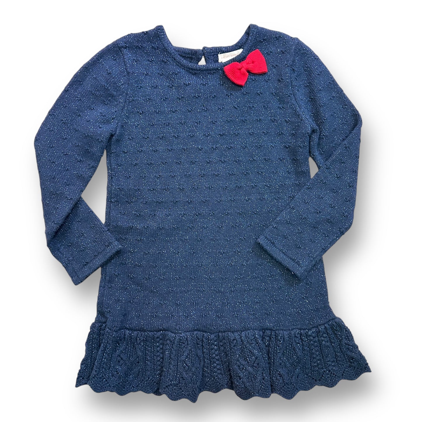 A dark blue shimmery sweater dress with a flowered pattern and a red bow detail on the shoulder.