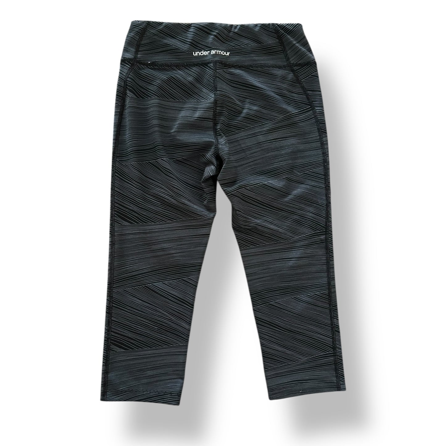 Black patterned leggings with 'Under Armour' branding on a white background