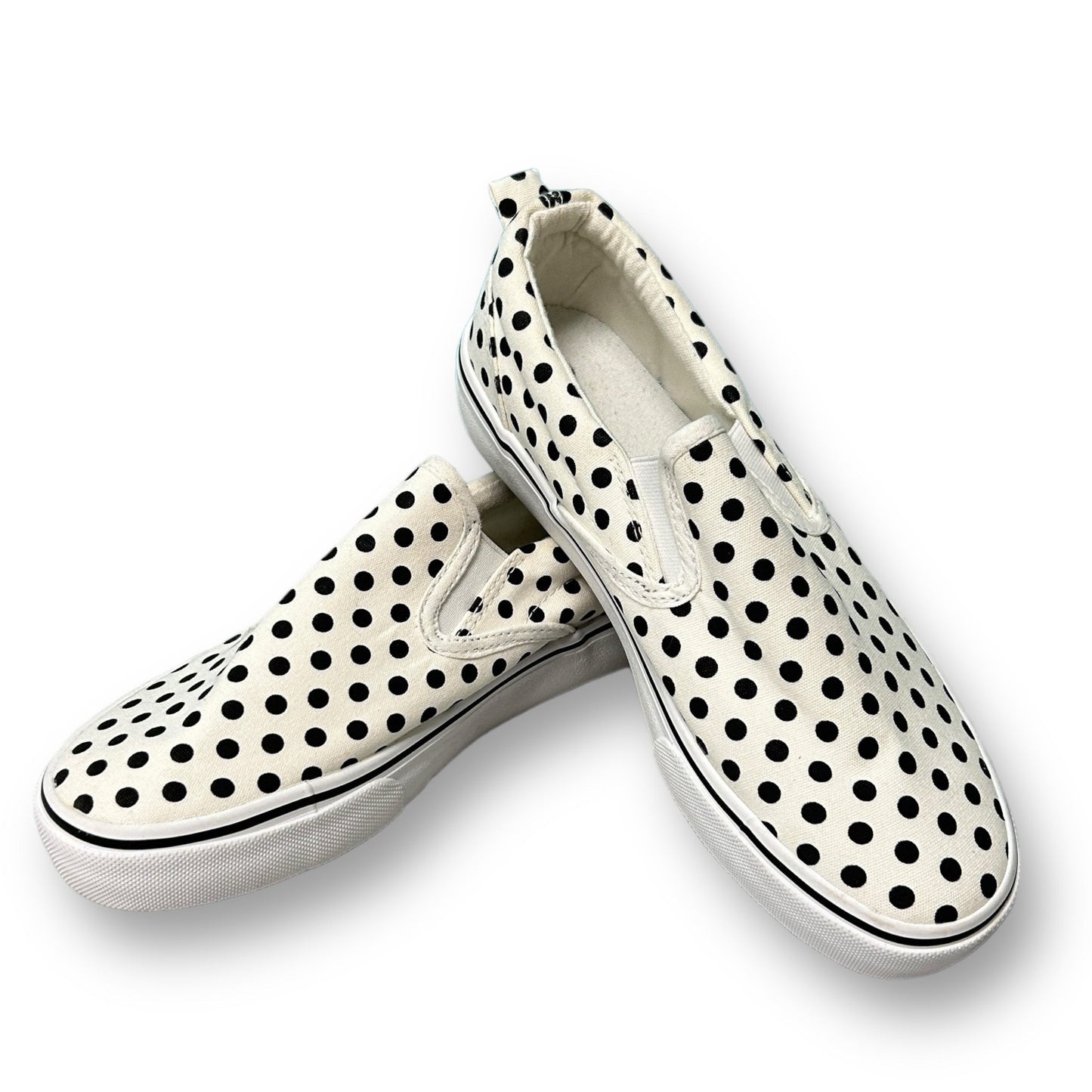 A pair of black and white dotted canvas youth girl slip-on shoes