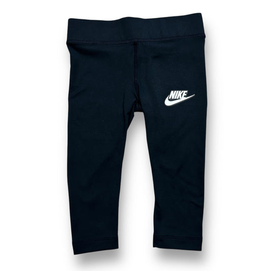 A pair of girls' Nike size 2T black athletic stretch capri leggings with a visible Nike logo on the upper left thigh.