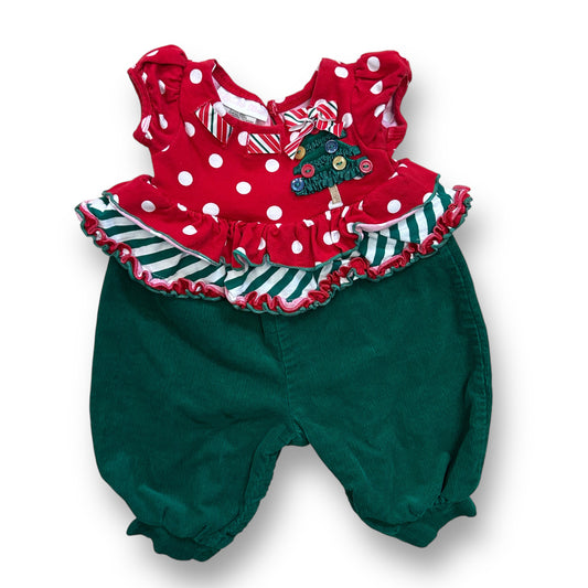 A green and red baby romper with ruffles and a Christmas-themed decoration on the waistband.