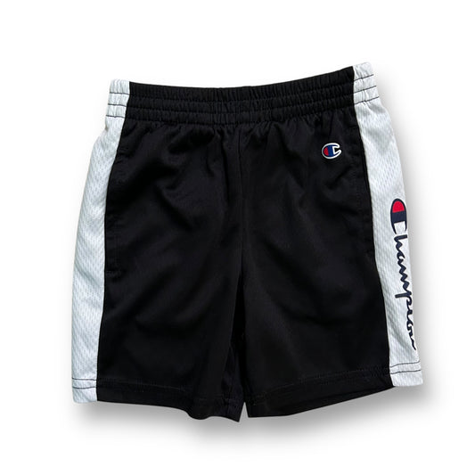 A pair of boys' athletic shorts with black color and a white brand logo on the left thigh.