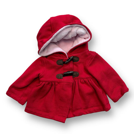 A red midweight jacket for a 6-month-old girl with a pink fur-lined hood and brown accents.