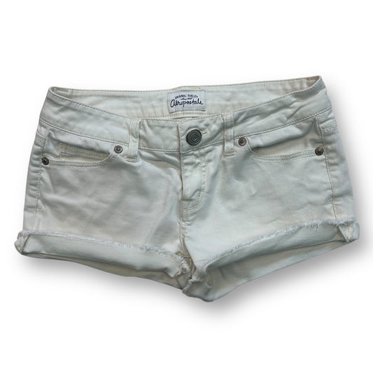 Women's denim cutoff white jean shorts with a mid-rise waist and five pockets.