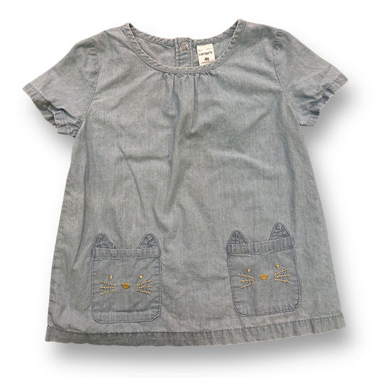 A short-sleeved light blue denim blouse for girls with cat face applique on the front pockets.