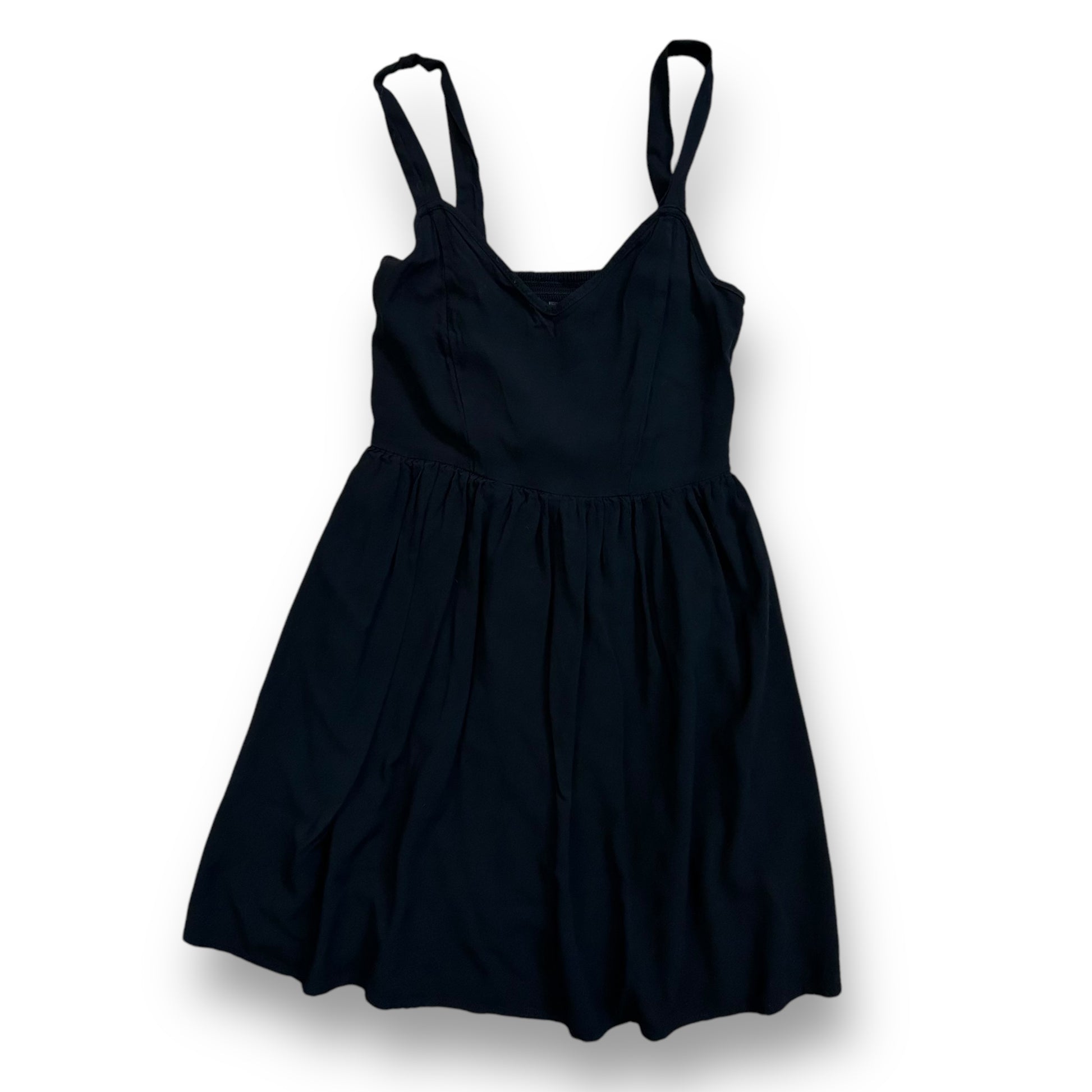 A black sleeveless knee-length dress with empire waist and thin straps.