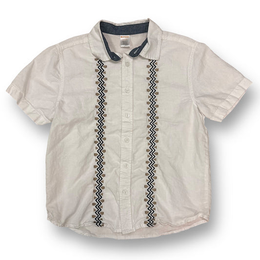 A white, short-sleeved boys' shirt with embroidered detailing and a button down collar.