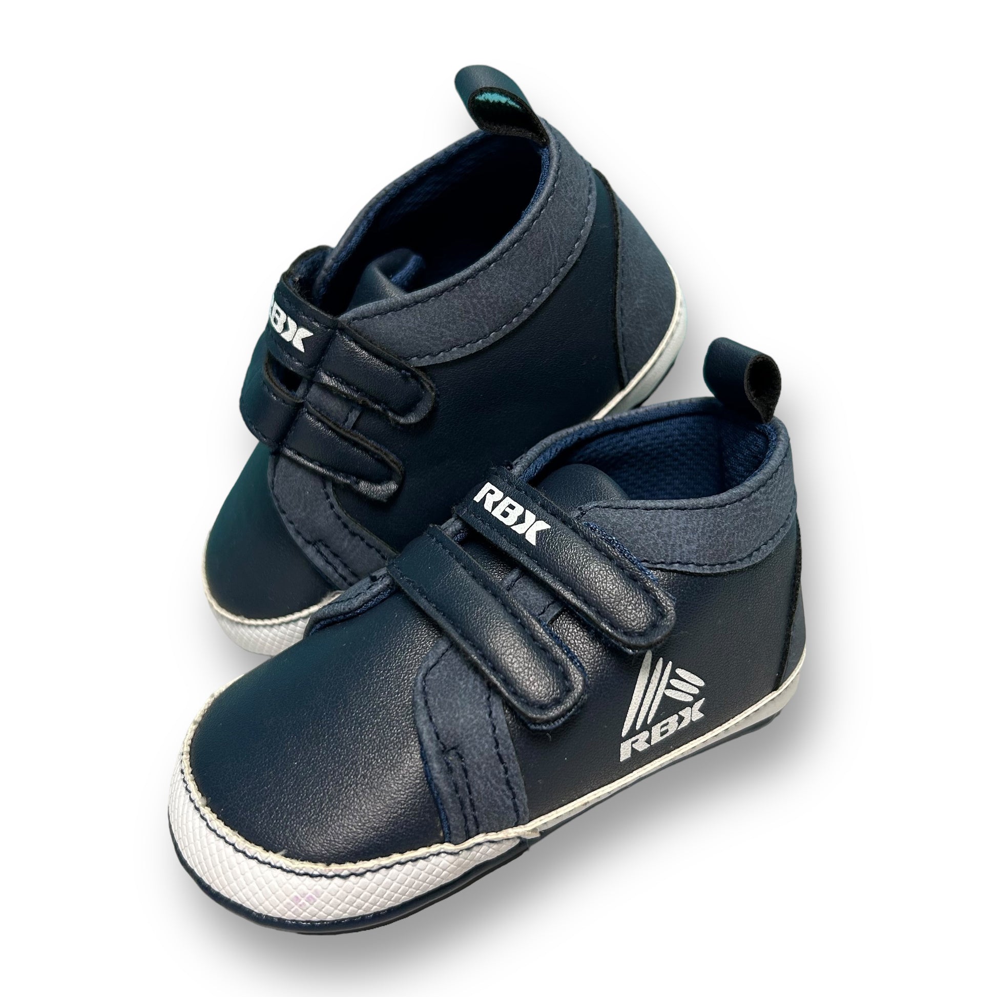 A navy-colored, leather style toddler sneaker with no-tie design and RBX branding on the side.