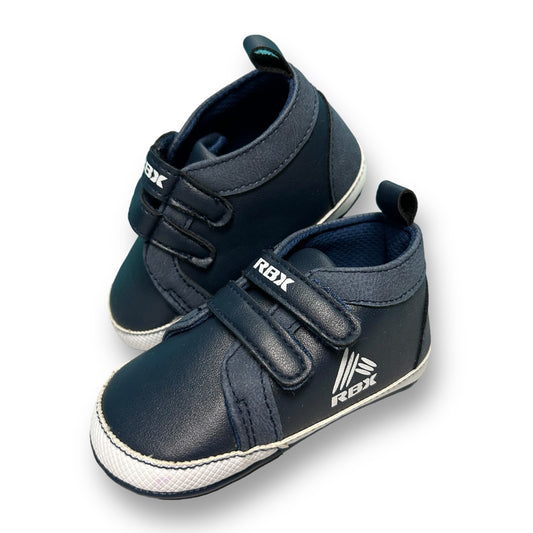 A navy-colored, leather style toddler sneaker with no-tie design and RBX branding on the side.