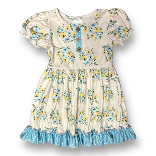 A floral print soft twirl dress with an ivory color and blue accents, featuring a round neckline and short sleeves.