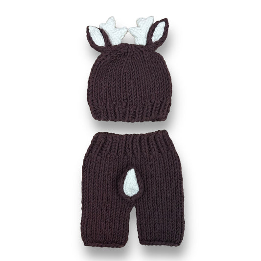 A handcrafted brown knit outfit for newborn boys shaped like a reindeer, including a hat with antlers and a matching pair of pants.