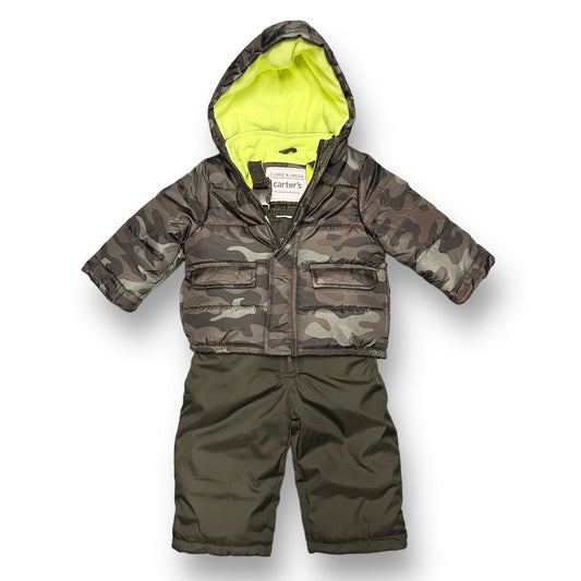A green camouflage winter coat and bib overall snow suit for a toddler.