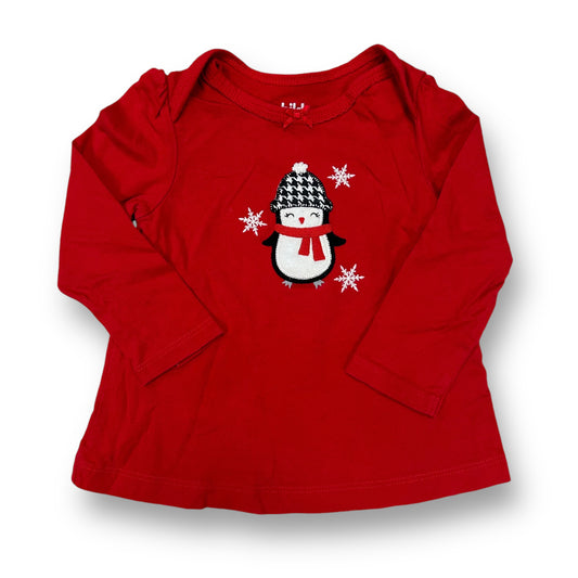 A red holiday-themed toddler shirt with a white snowflake and a black penguin graphic on the front.