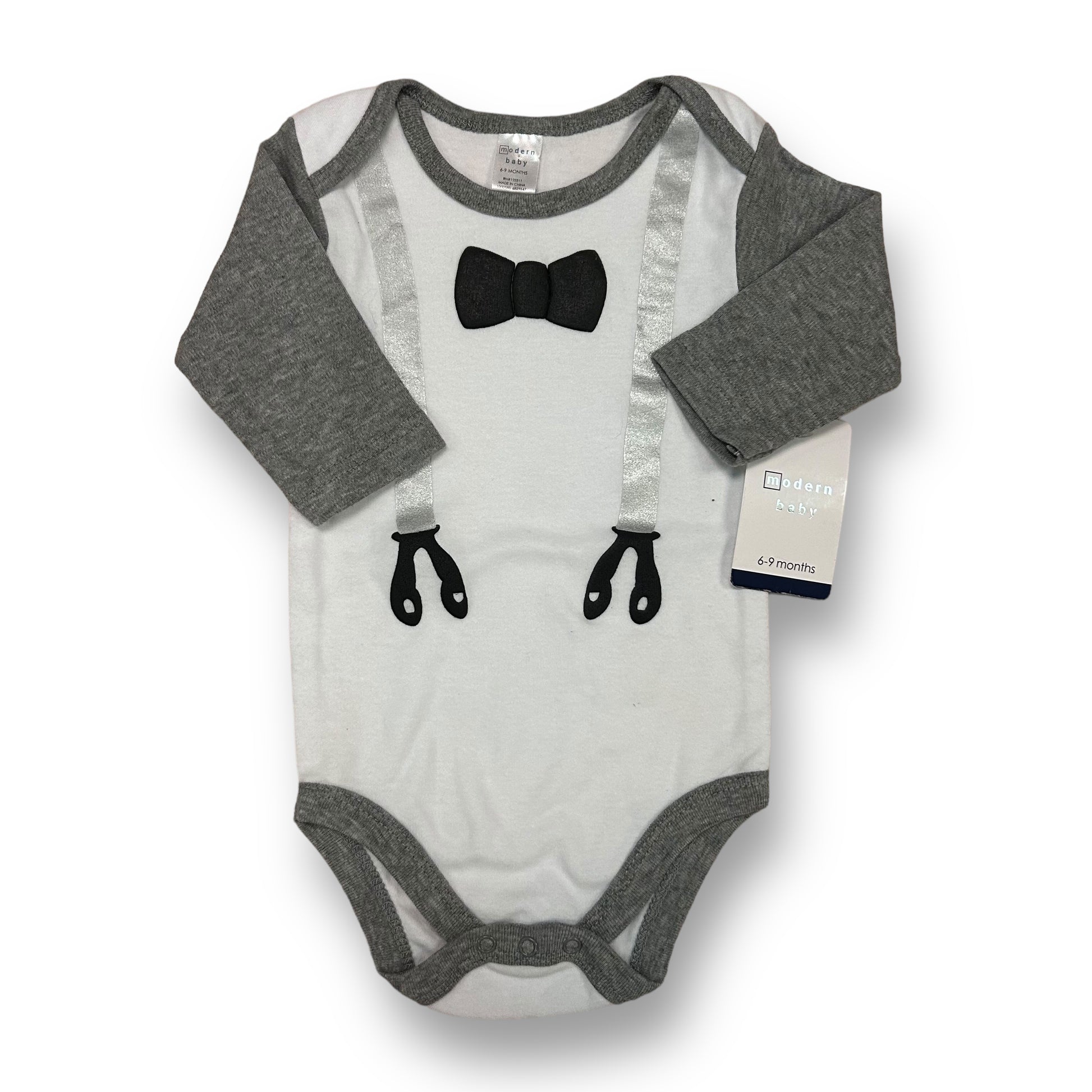 A white and gray baby tuxedo bodysuit with long sleeves and a bow tie at the neck area. The bodysuit is displayed on a flat surface with the brand tag visible on the bottom right corner.