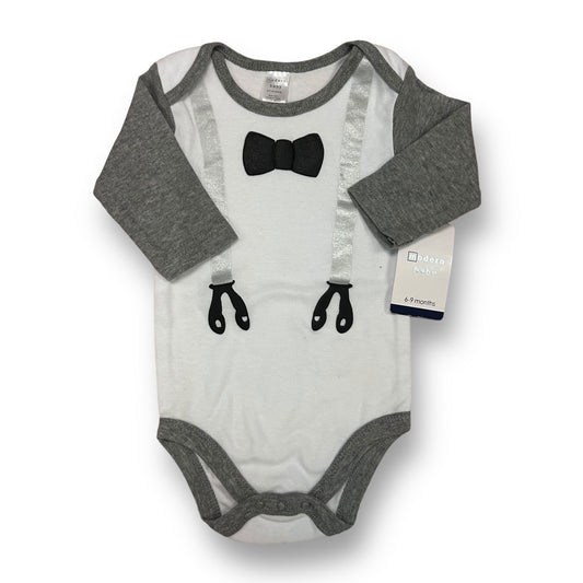 A white and gray baby tuxedo bodysuit with long sleeves and a bow tie at the neck area. The bodysuit is displayed on a flat surface with the brand tag visible on the bottom right corner.