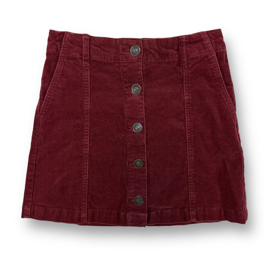 A maroon red corduroy button skirt with an elastic waist, featuring multiple buttons down the front.