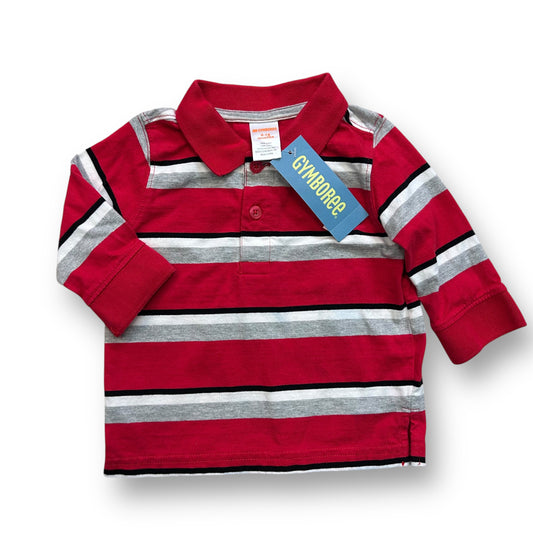 A long sleeve striped polo shirt for a baby boy, predominantly red with gray stripes, displayed with its packaging behind.
