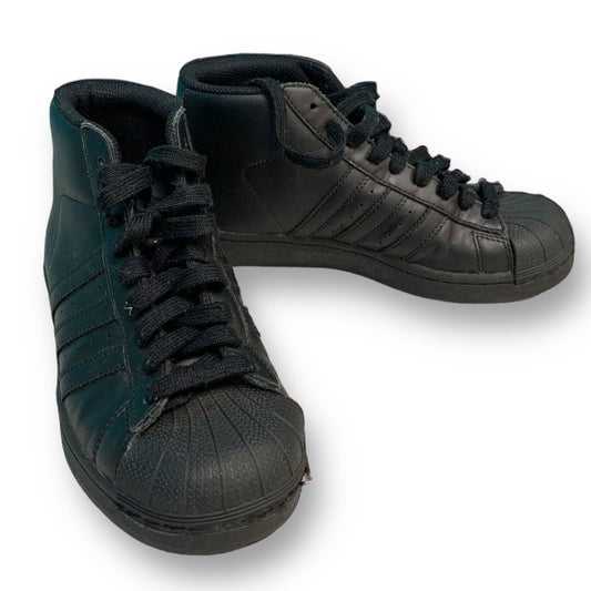A pair of Adidas youth girl size 3.5 black platform sneakers with lace-up closure.