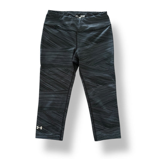 Black patterned leggings with Under Armour logo on a white background