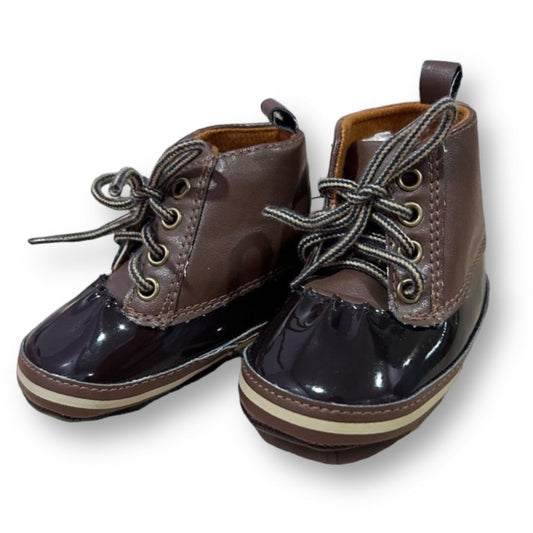 A pair of brown baby boy boots with lace-up closure and a glossy finish.