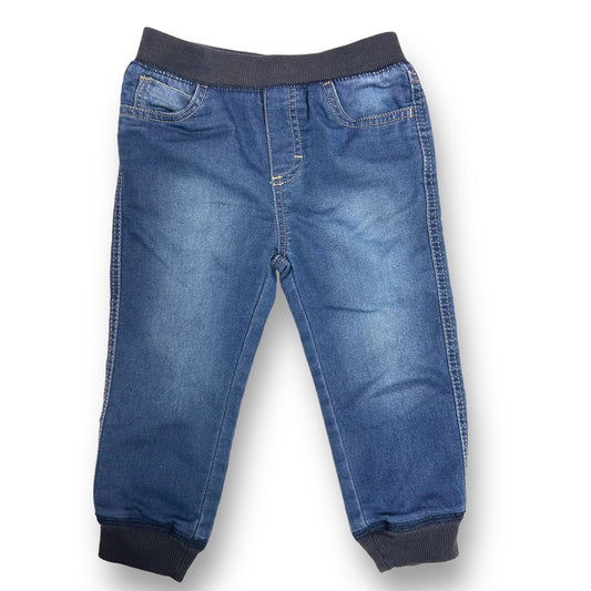 A pair of blue denim joggers for boys, with an elastic band waist.