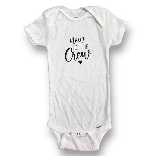 White short-sleeved onesie with 'NEW TO THE CREW' printed in black text on the front.