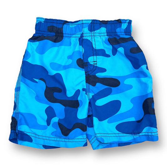 Blue camouflage patterned swim trunks for children with adjustable waist, displayed on a white background.