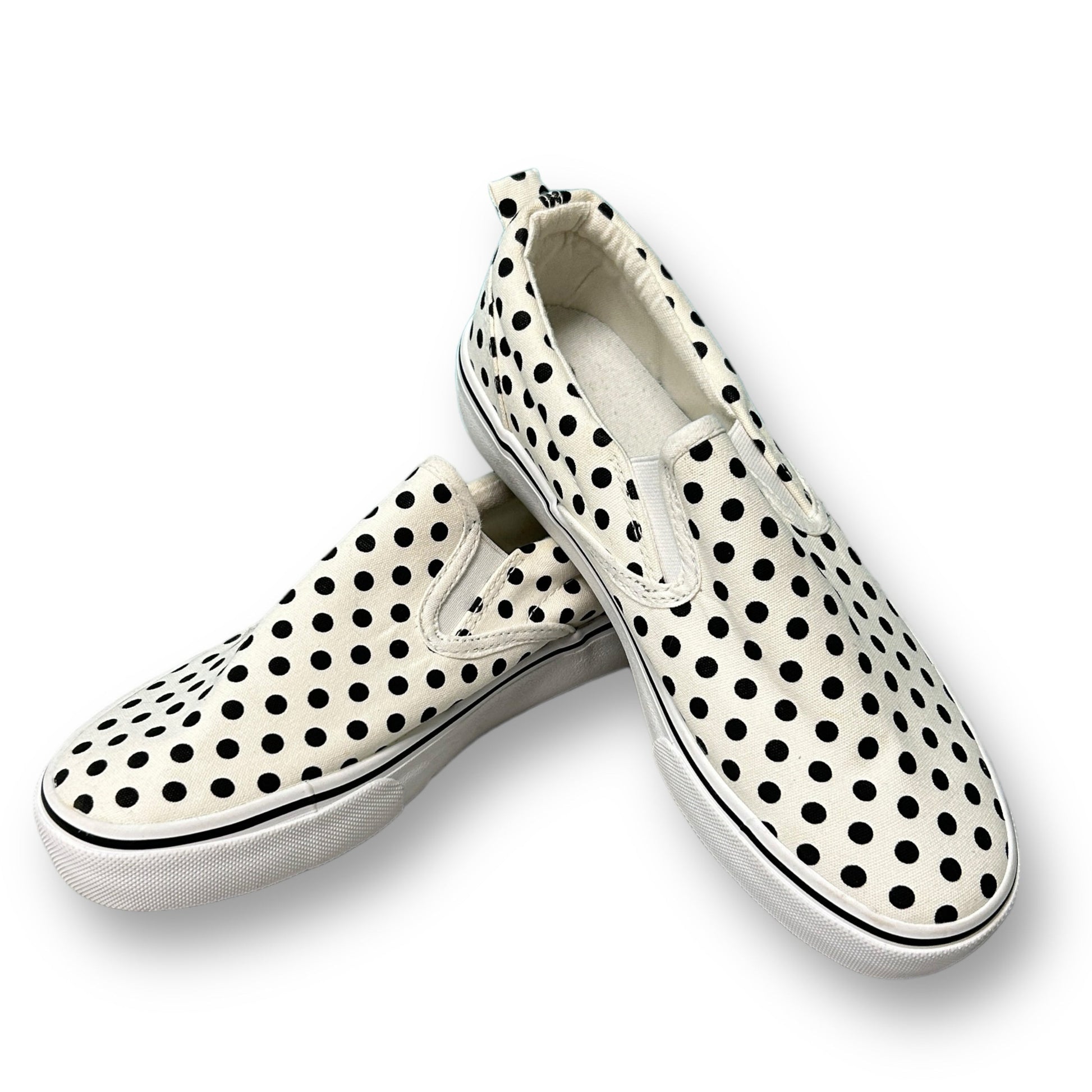 A pair of black and white dotted canvas youth girl slip-on shoes
